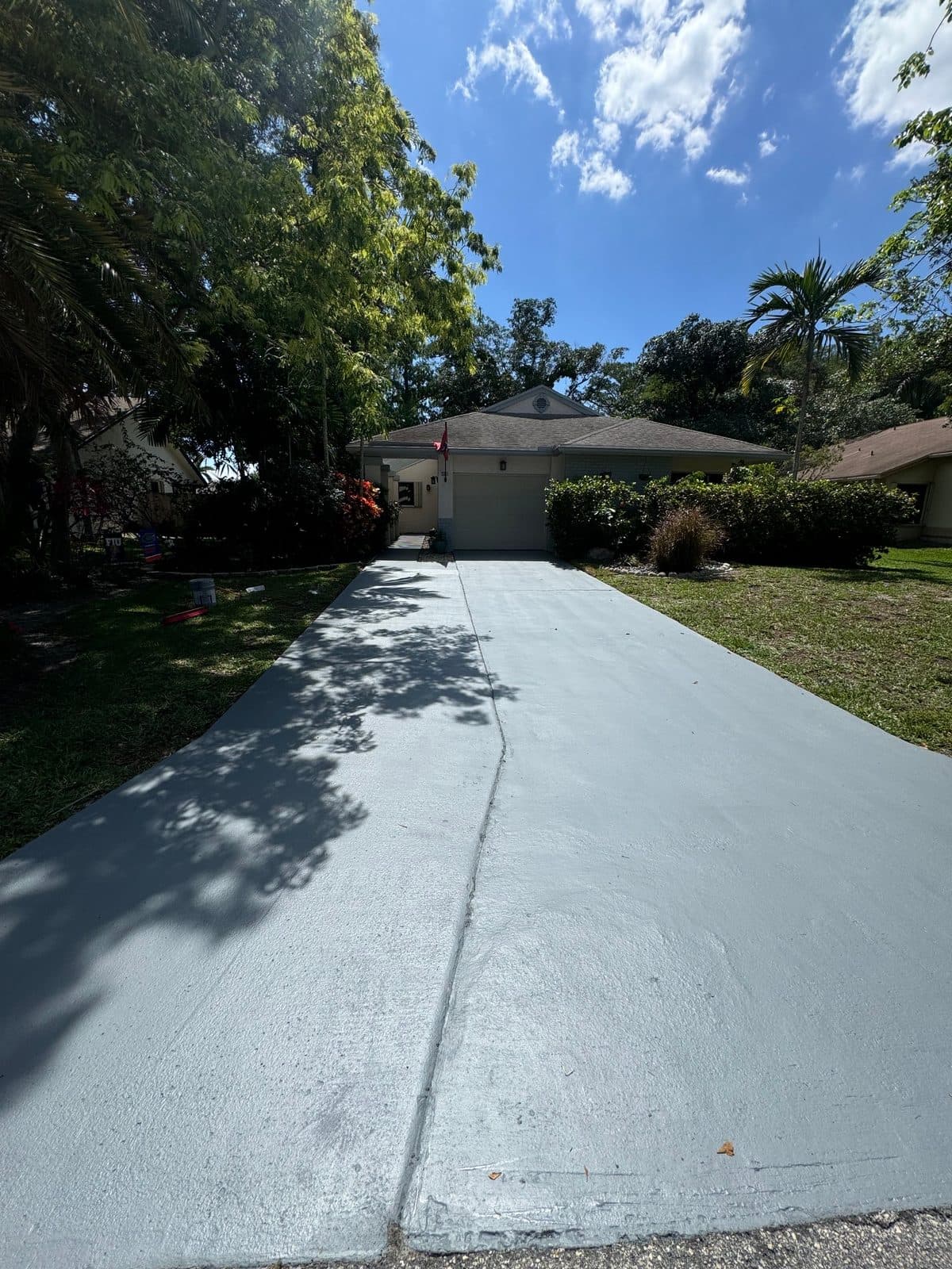 Freshly pressure-washed concrete driveway under blue sky